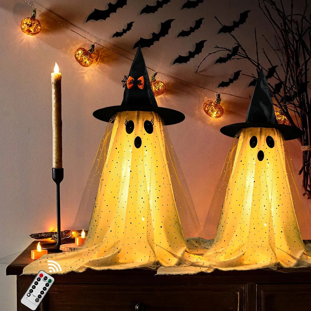 Light-Up Witch Hat Ghosts – two ghosts glowing on a table with the remote